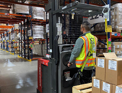 Person in warehouse driving a forklift